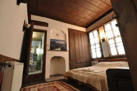 Standart Oda’da yatak ve ahşap pencere görünümü