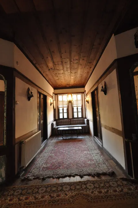 A wooden-ceilinged corridor leading to a window